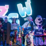 Cosplay competition winners on stage at Zagreb Games Week holding Best in Show, Runner Up and Best Performance signs