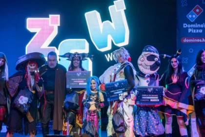 Cosplay competition winners on stage at Zagreb Games Week holding Best in Show, Runner Up and Best Performance signs