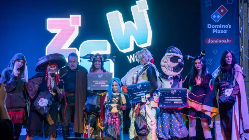 Cosplay competition winners on stage at Zagreb Games Week holding Best in Show, Runner Up and Best Performance signs